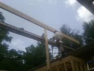 Carpenter setting a ridge beam over a new addition frame — Ice Dam Removal by Roofing Brothers in Radiant