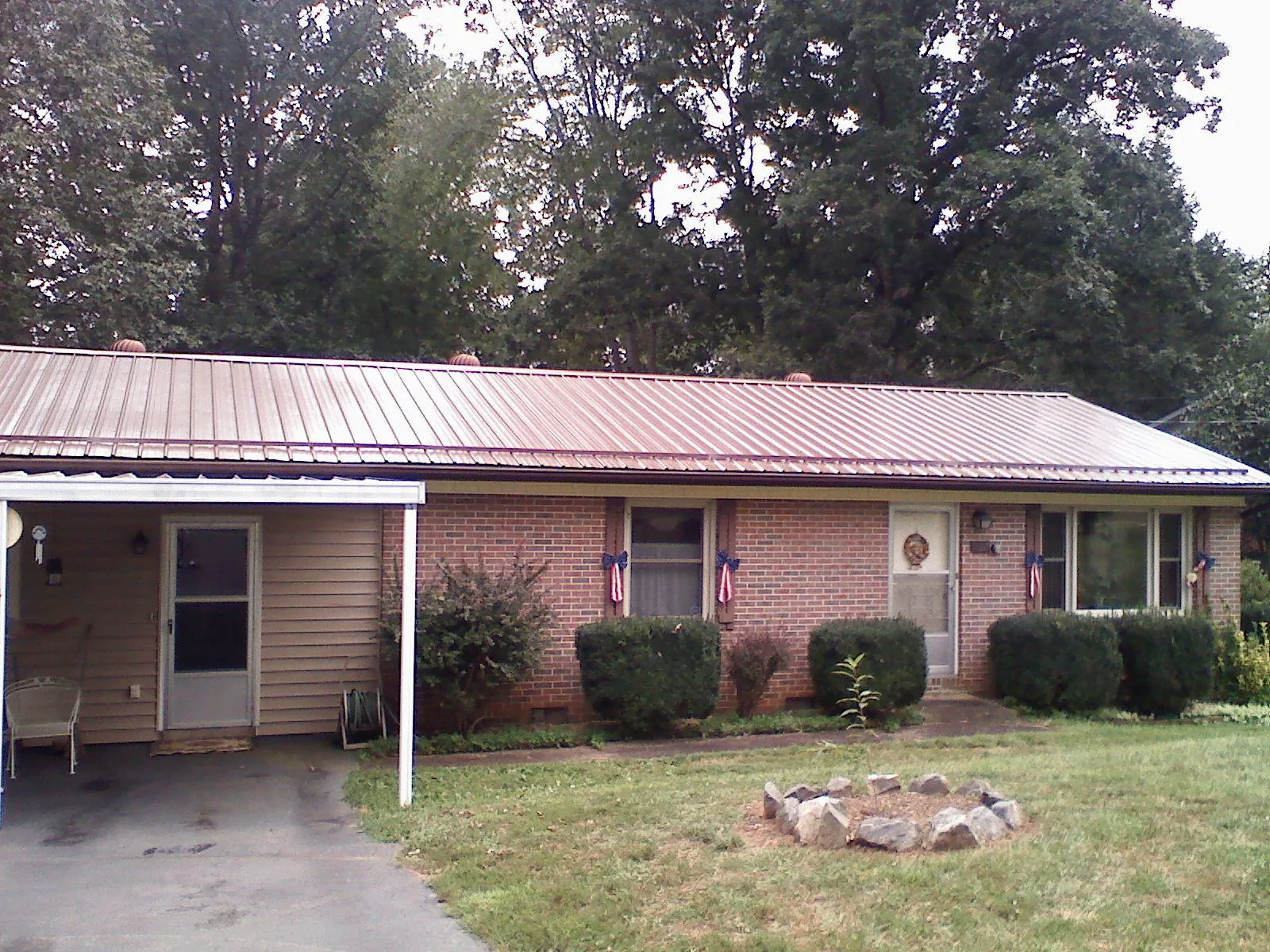 Bronze metal roof and carport on a brick ranch home — Roof Repair work by our crew in Radiant