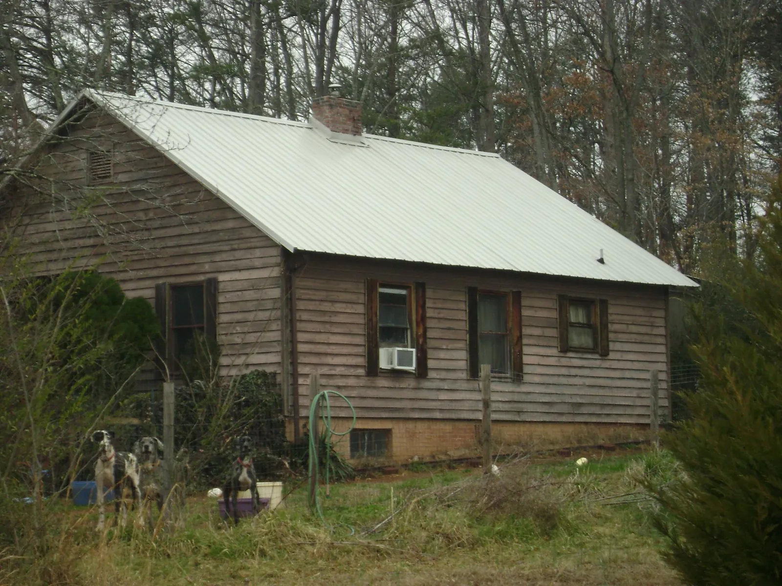White metal roof on an old wood sided farmhouse, from a Metal Roof Installation job in Radiant